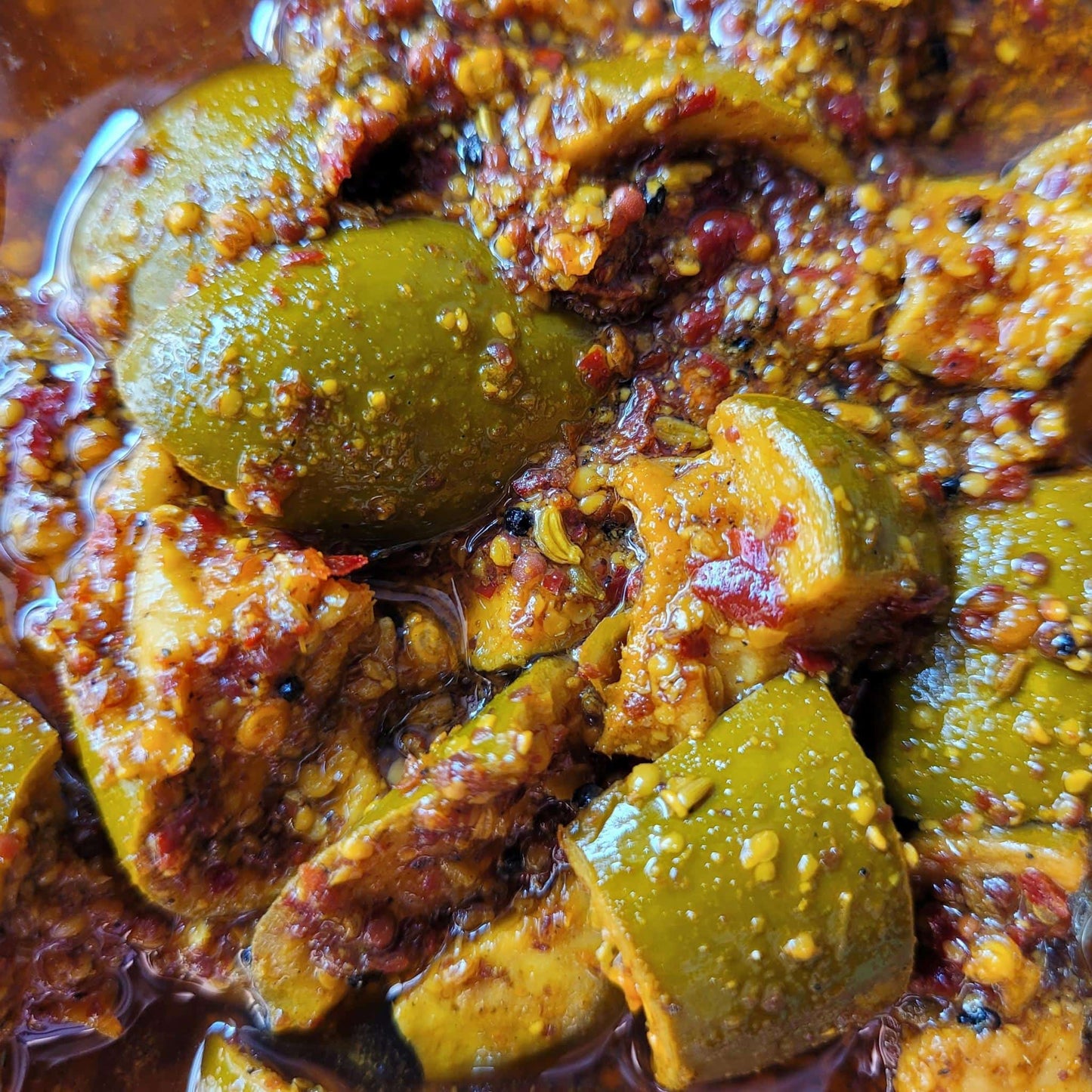 tangy mango pickle in spices and mustard oil